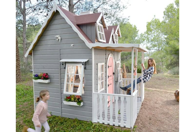 Kinder spielen in einer holzernen Spielhütte im Freien