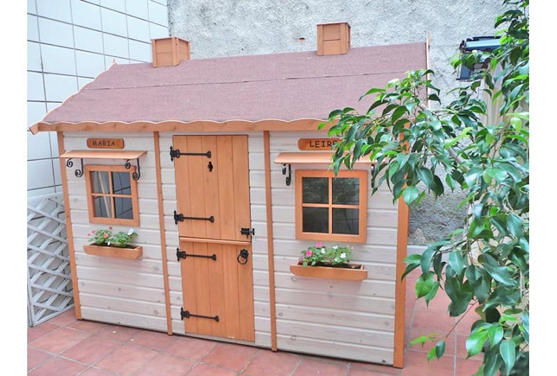 Kinder spielen in einer holzernen Spielhütte im Freien