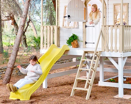 Kinder spielen in einer holzernen Spielhütte im Freien