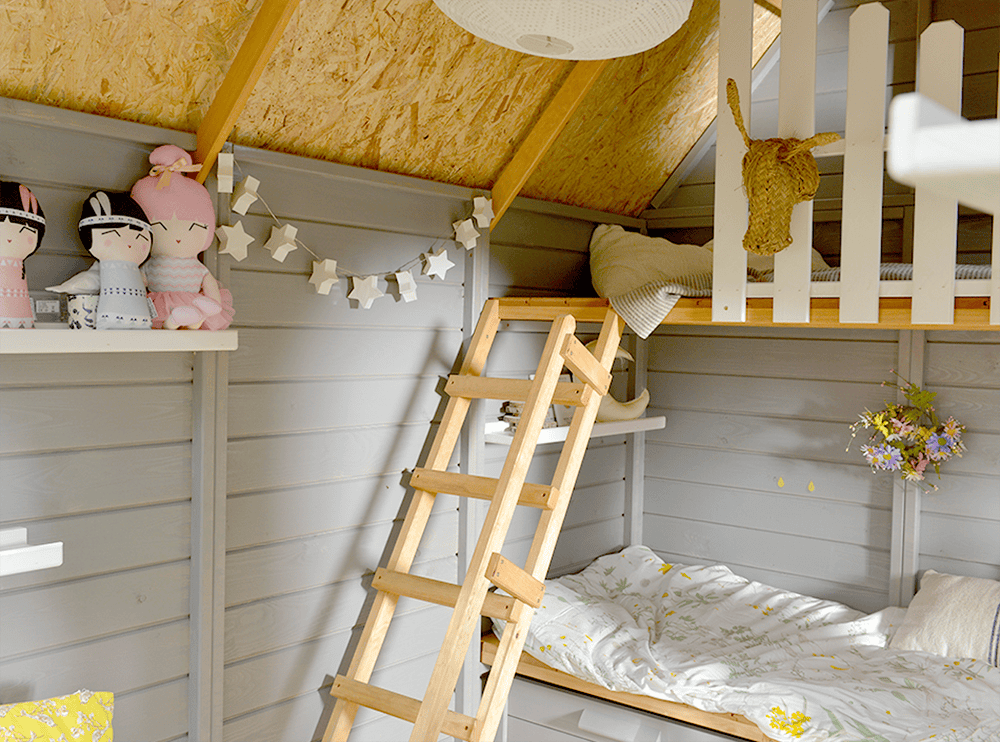 Kinder spielen in einer holzernen Spielhütte im Freien