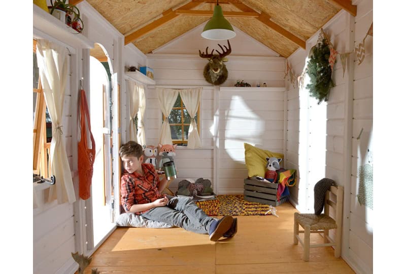 Kinder spielen in einer holzernen Spielhütte im Freien