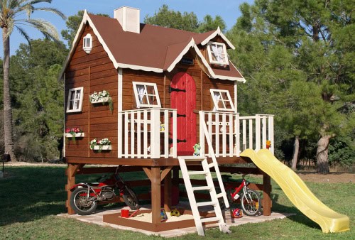 Kinder spielen in einer holzernen Spielhütte im Freien