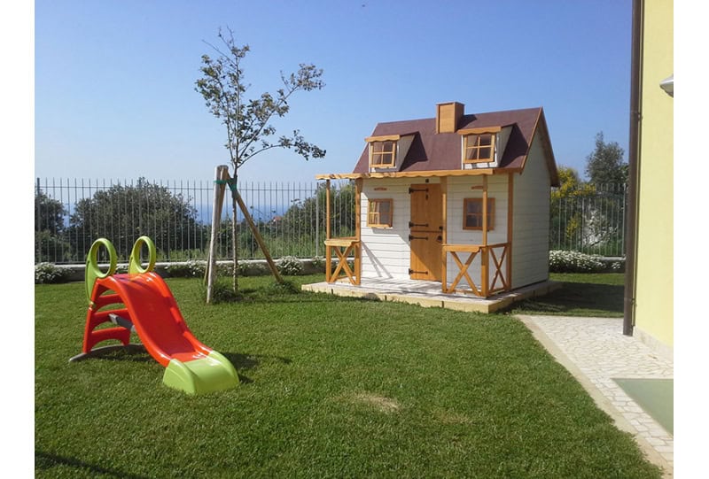 Kinder spielen in einer holzernen Spielhütte im Freien