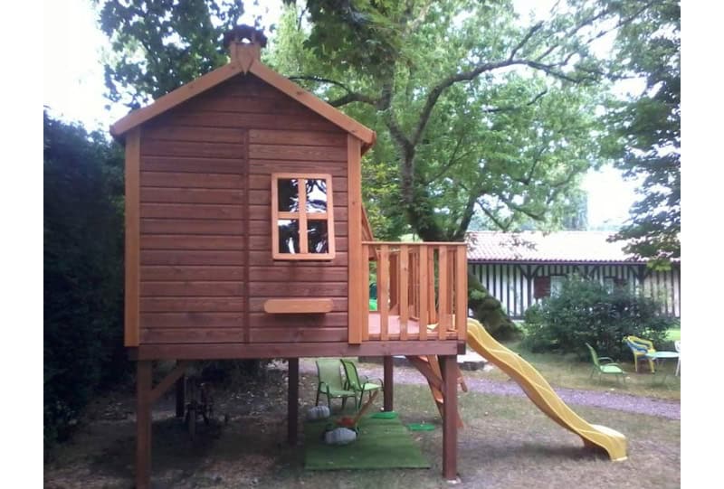 Kinder spielen in einer holzernen Spielhütte im Freien