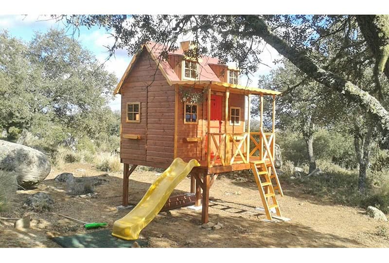 Kinder spielen in einer holzernen Spielhütte im Freien