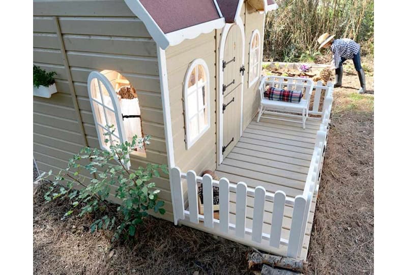 Kinder spielen in einer holzernen Spielhütte im Freien