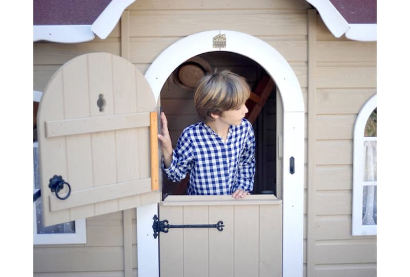 Kinder spielen in einer holzernen Spielhütte im Freien