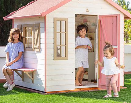 Kinder spielen in einer holzernen Spielhütte im Freien