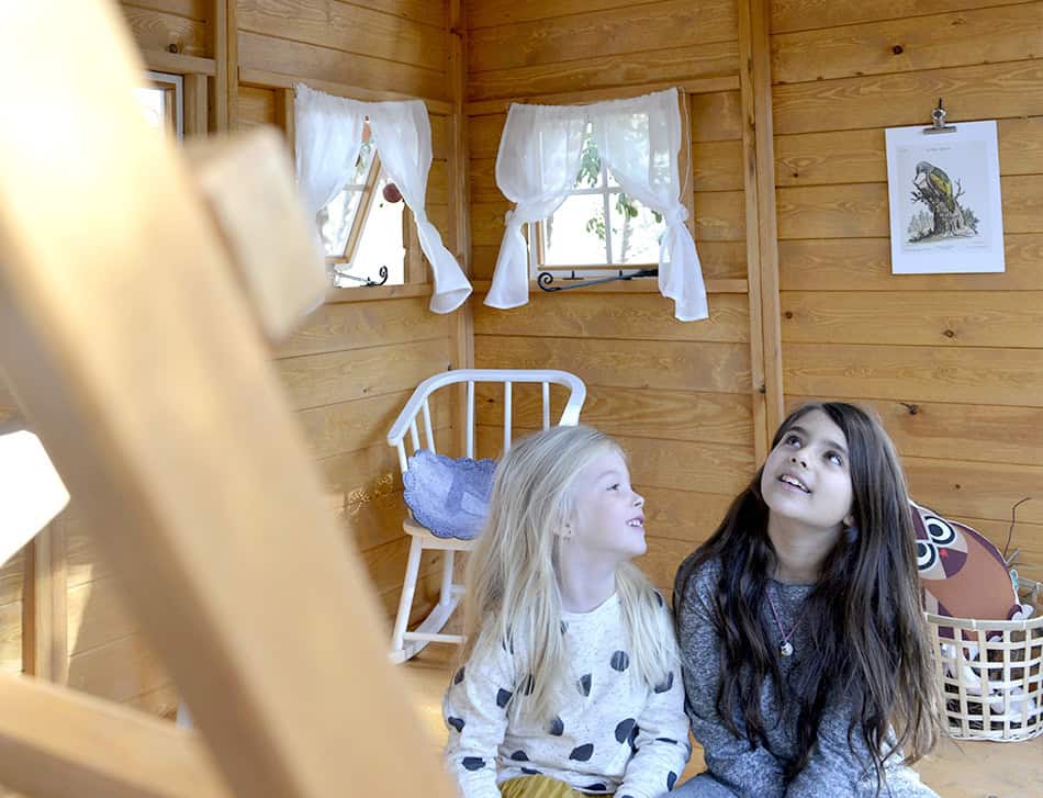 Petits Belges jouant dans une cabane en bois à l'extérieur