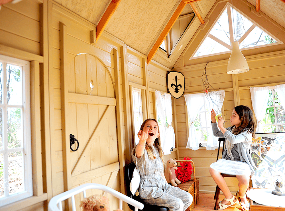 Petits Belges jouant dans une cabane en bois à l'extérieur
