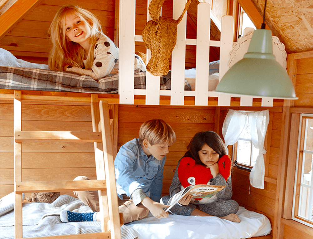 Petits Belges jouant dans une cabane en bois à l'extérieur