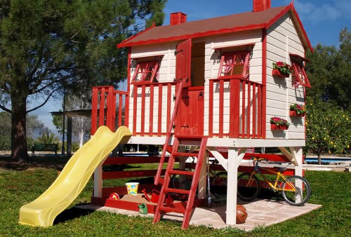 Petits Belges jouant dans une cabane en bois à l'extérieur