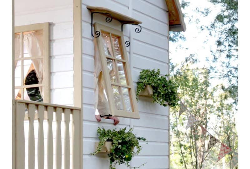 Petits Belges jouant dans une cabane en bois à l'extérieur