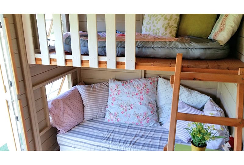 Petits Belges jouant dans une cabane en bois à l'extérieur