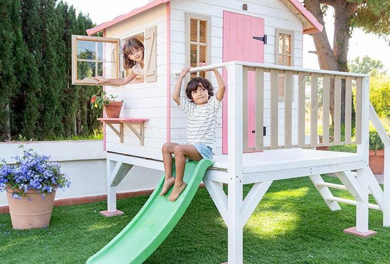 Petits Belges jouant dans une cabane en bois à l'extérieur