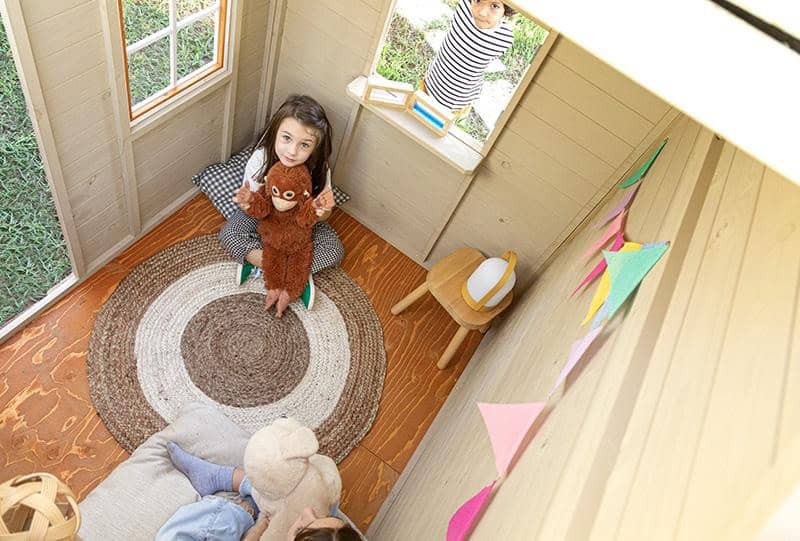 Petits Belges jouant dans une cabane en bois à l'extérieur