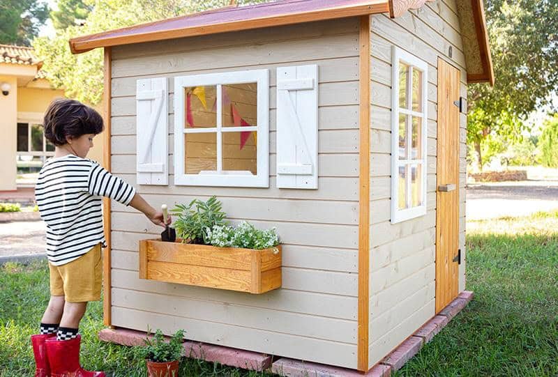 Petits Belges jouant dans une cabane en bois à l'extérieur