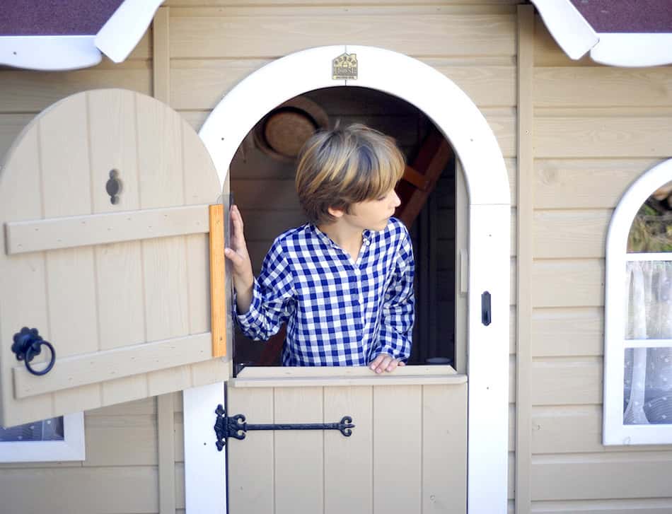 Kinder spielen in einem hölzernen Spielhaus im Freien