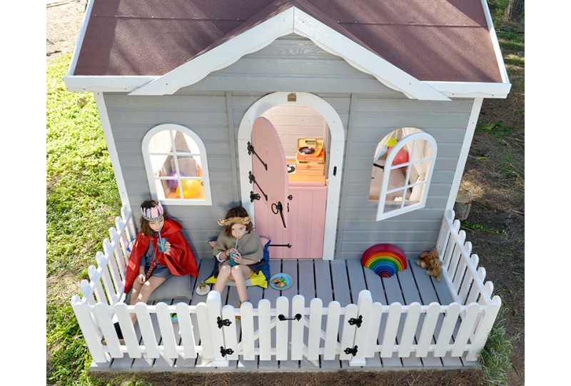 Kinder spielen in einem hölzernen Spielhaus im Freien