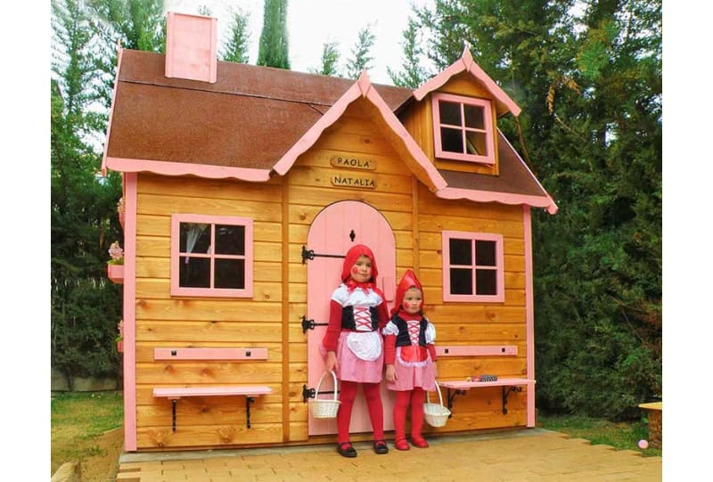 Kinder spielen in einem hölzernen Spielhaus im Freien