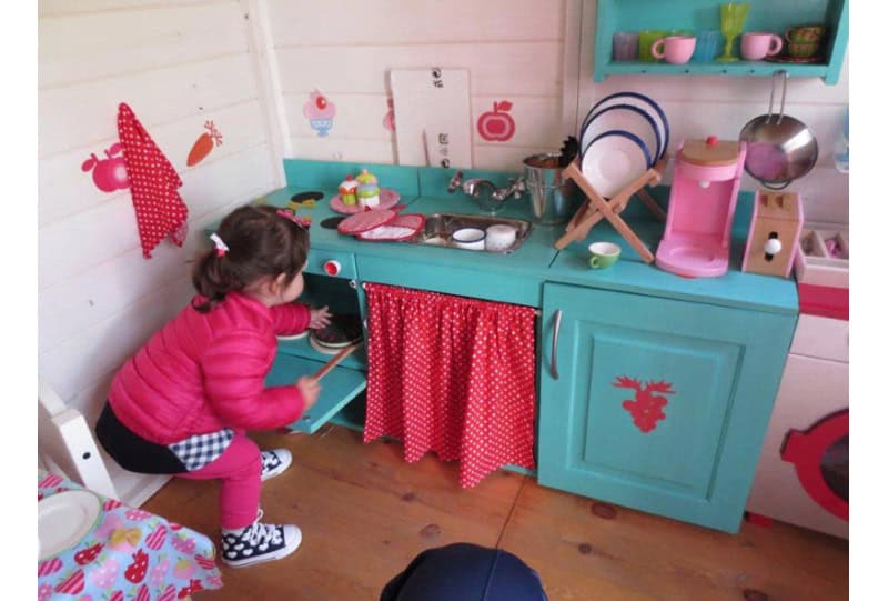 Kinder spielen in einem hölzernen Spielhaus im Freien