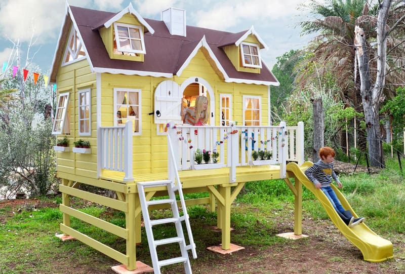 Kinder spielen in einem hölzernen Spielhaus im Freien