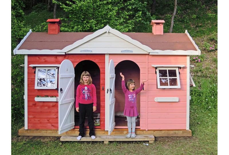 Kinder spielen in einem hölzernen Spielhaus im Freien