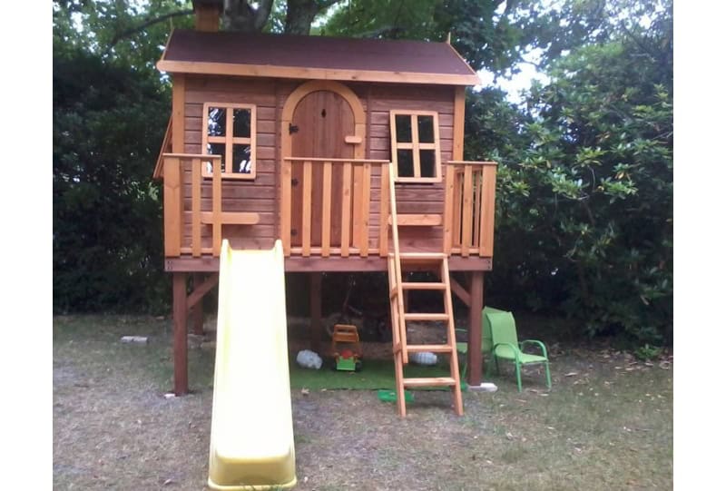 Kinder spielen in einem hölzernen Spielhaus im Freien