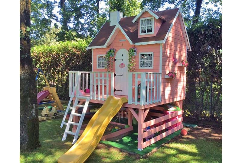 Kinder spielen in einem hölzernen Spielhaus im Freien