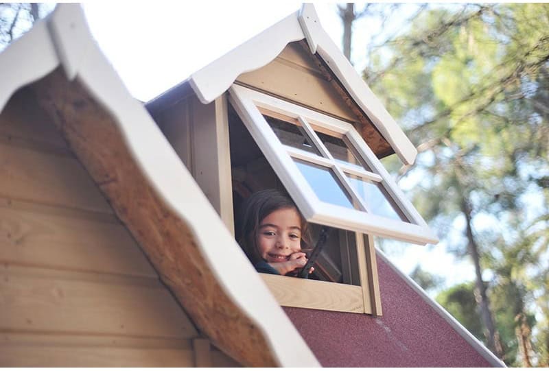 Kinder spielen in einem hölzernen Spielhaus im Freien