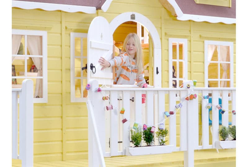 Kinder spielen in einem hölzernen Spielhaus im Freien