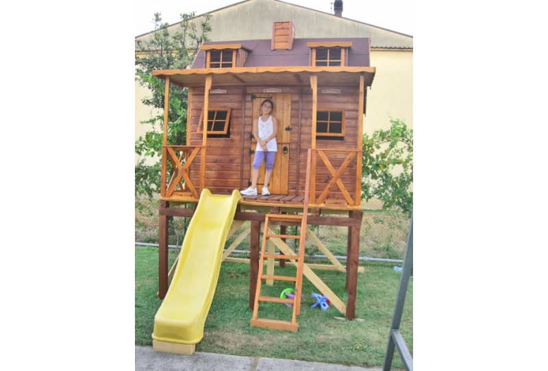 Kinder spielen in einem hölzernen Spielhaus im Freien