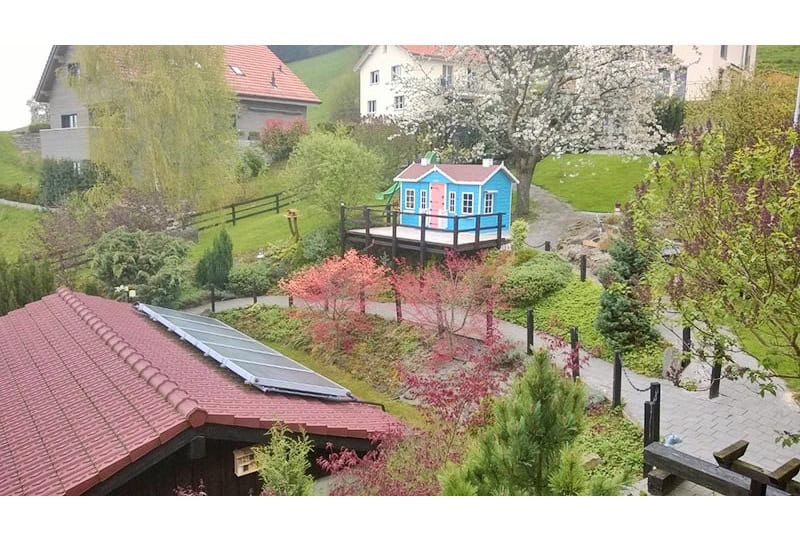 Kinder spielen in einem hölzernen Spielhaus im Freien