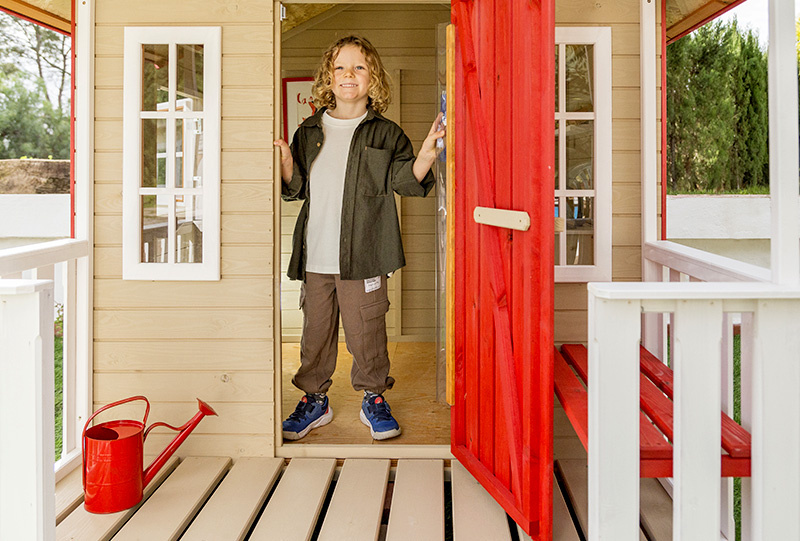 Kinder spielen in einem hölzernen Spielhaus im Freien