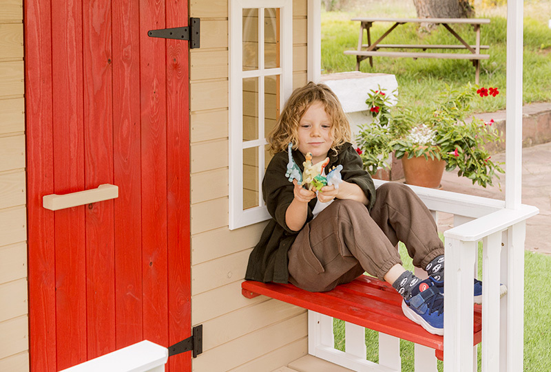 Kinder spielen in einem hölzernen Spielhaus im Freien