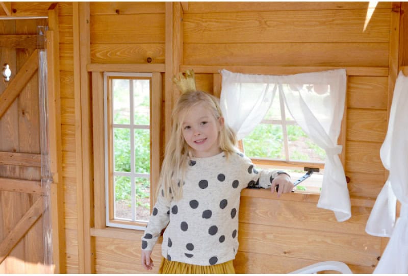 Enfants jouant dans une cabane en bois à l'extérieur