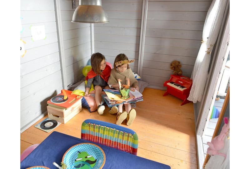 Enfants jouant dans une cabane en bois à l'extérieur