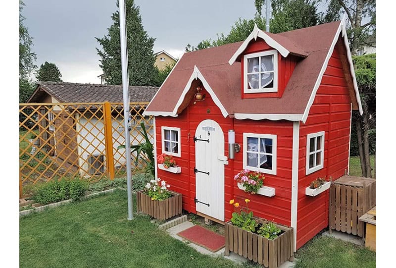 Enfants jouant dans une cabane en bois à l'extérieur