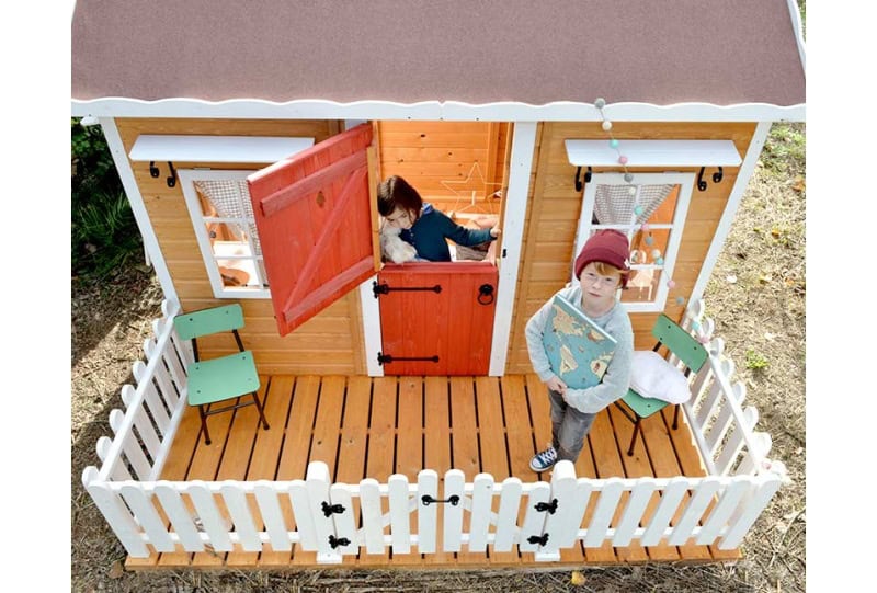 Enfants jouant dans une cabane en bois à l'extérieur