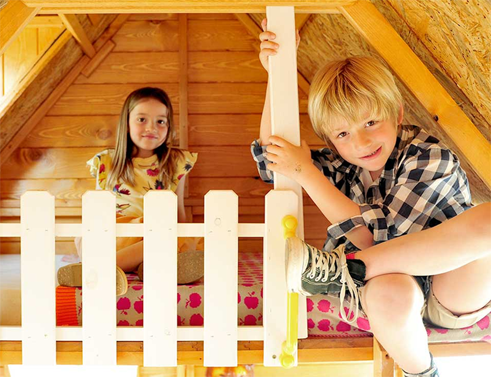 Enfants jouant dans une cabane en bois à l'extérieur
