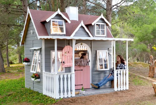 Enfants jouant dans une cabane en bois à l'extérieur