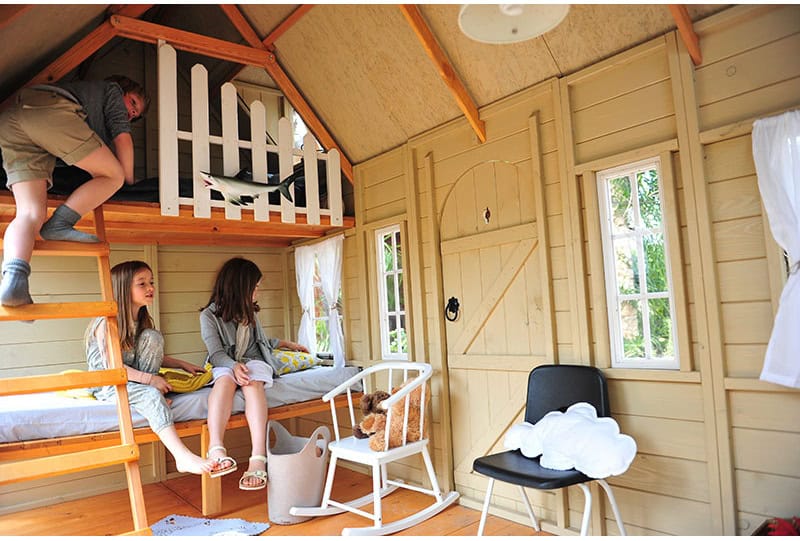 Enfants jouant dans une cabane en bois à l'extérieur