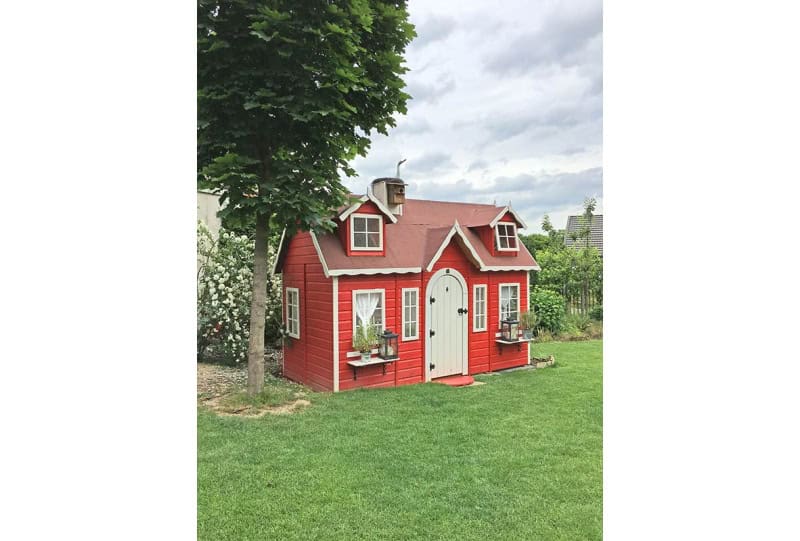 Enfants jouant dans une cabane en bois à l'extérieur