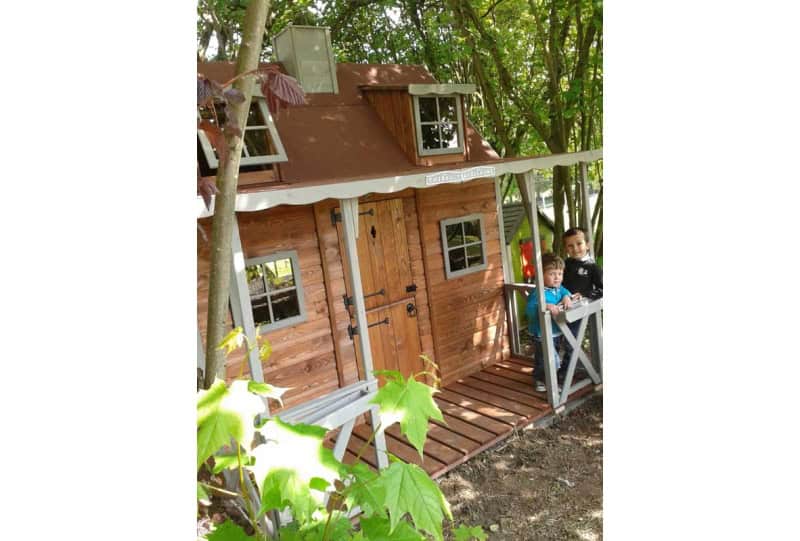 Enfants jouant dans une cabane en bois à l'extérieur