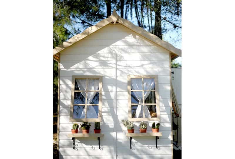 Enfants jouant dans une cabane en bois à l'extérieur