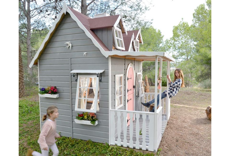 Bambini che giocano in una casetta di legno all'aperto