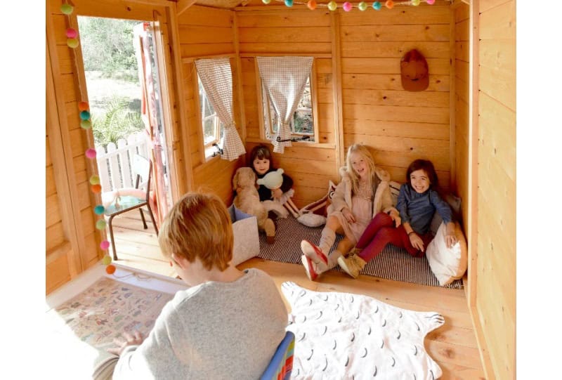 Bambini che giocano in una casetta di legno all'aperto