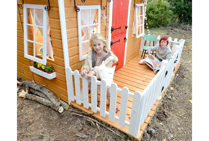 Bambini che giocano in una casetta di legno all'aperto