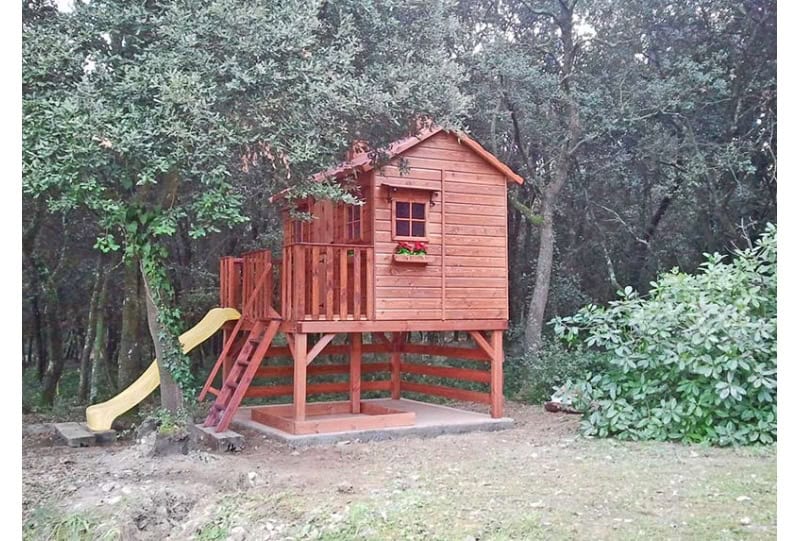 Crianças brincando em uma casinha de madeira ao ar livre